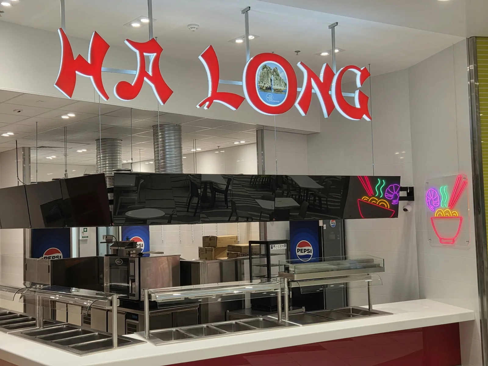 Restauracja Ha Long: litery „HA LONG” nad ladą z bufetem i neon LED z miską makaronu na szklanej ścianie